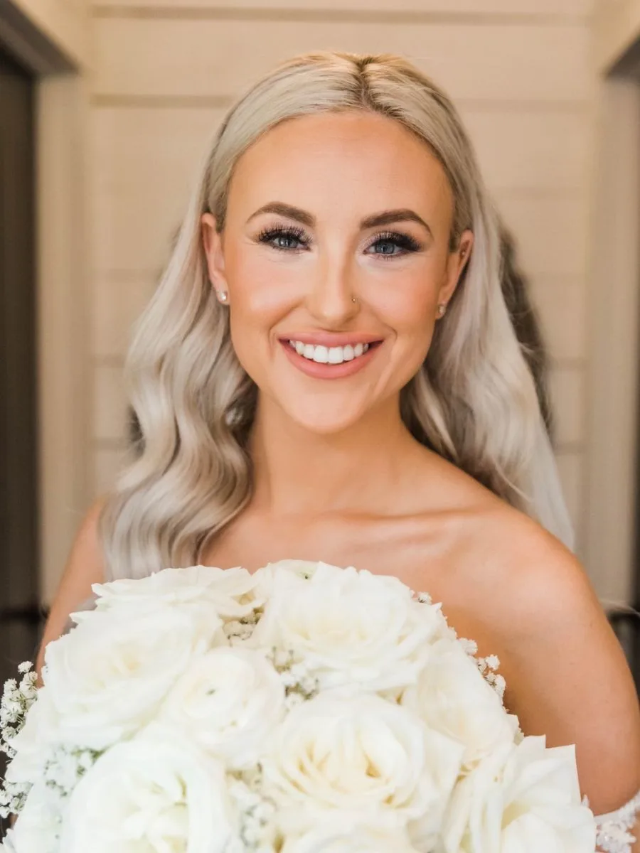 bride smiles on her wedding day showing off her new smile from Invisalign treatment with Doc Russell